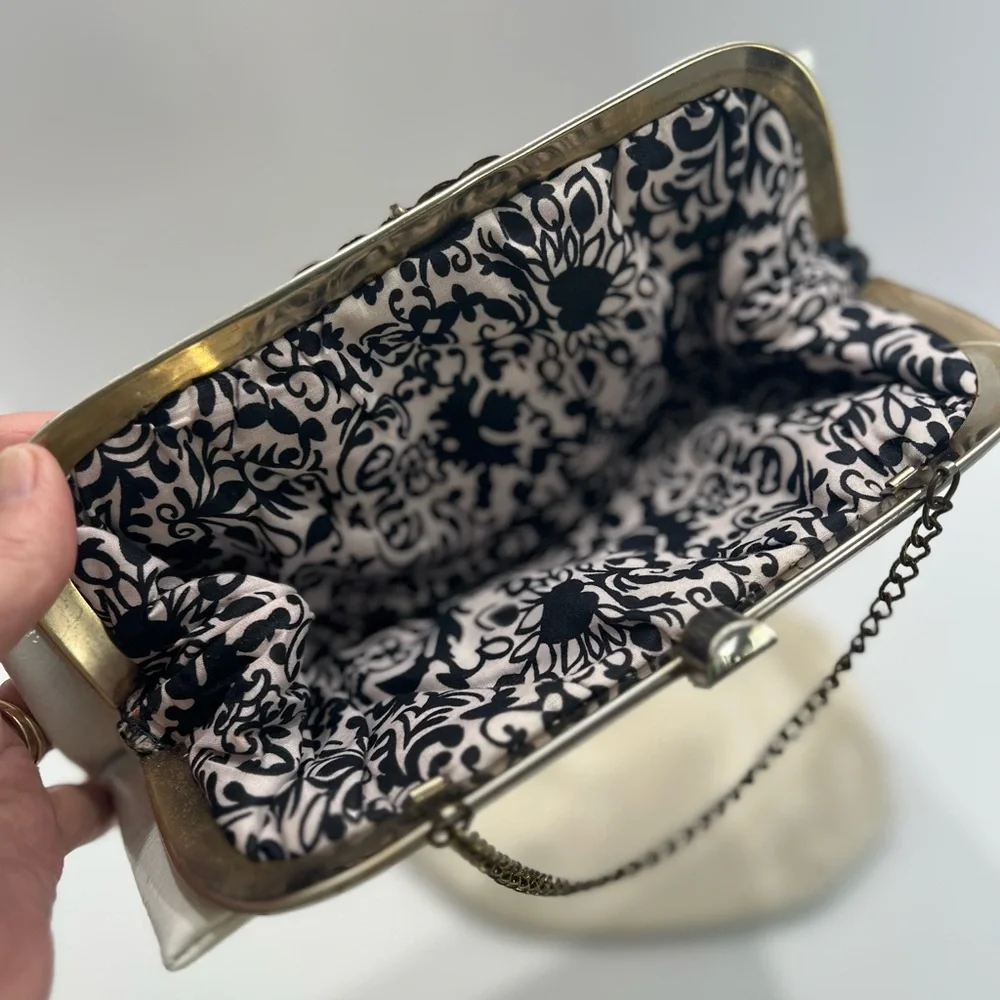 Vintage pair of white leather clutches, one is 70’s with great blk/white lining